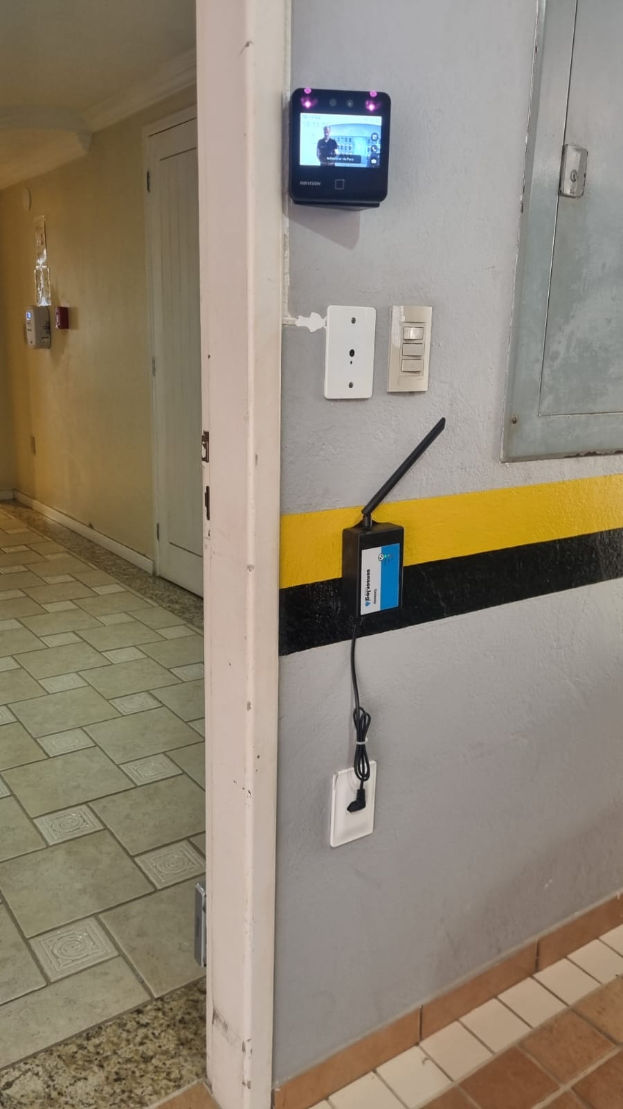 Gateway TeleNível instalado em parede de corredor, próximo a interfone
